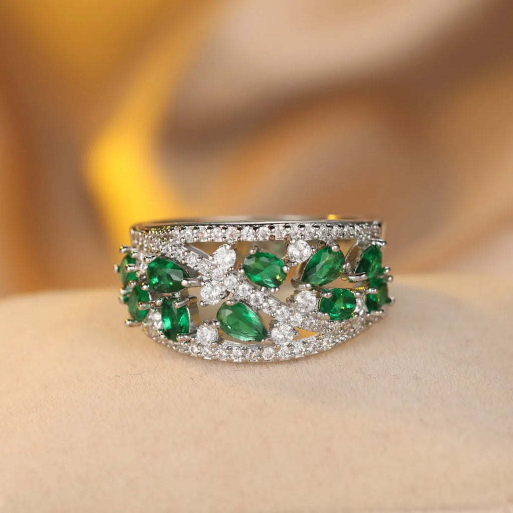 Women's hollow round fashion ring in gold and platinum finishes with blue and white stone accents.