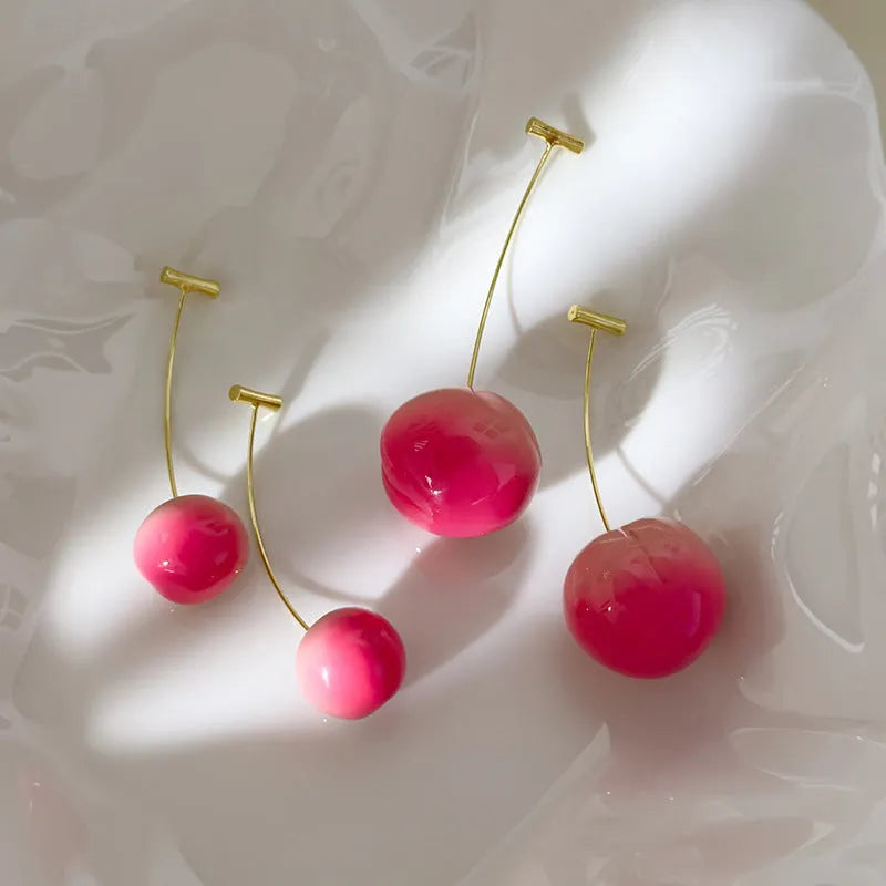 A pair of peach-shaped acrylic earrings on copper studs, shown in small and large size options.