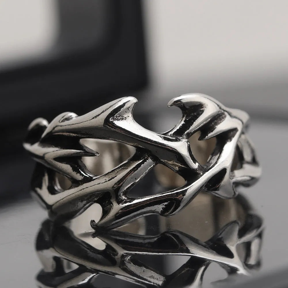 Copper geometric thorn and flower design ring with an adjustable opening on a dark background.