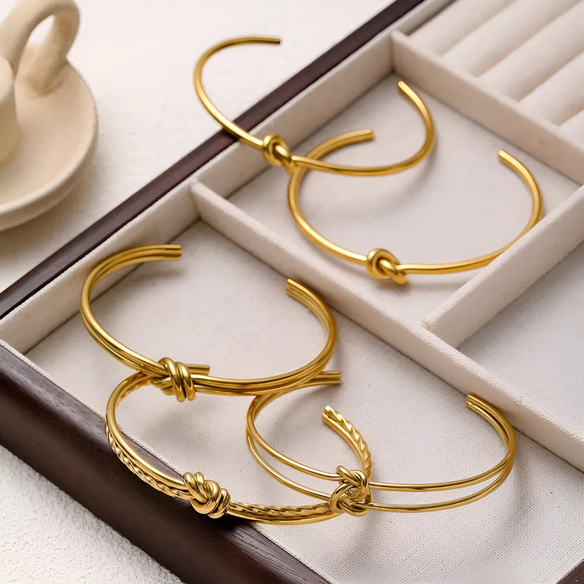 Adjustable stainless steel bracelet with 18K gold plating and knotted C-shaped open design