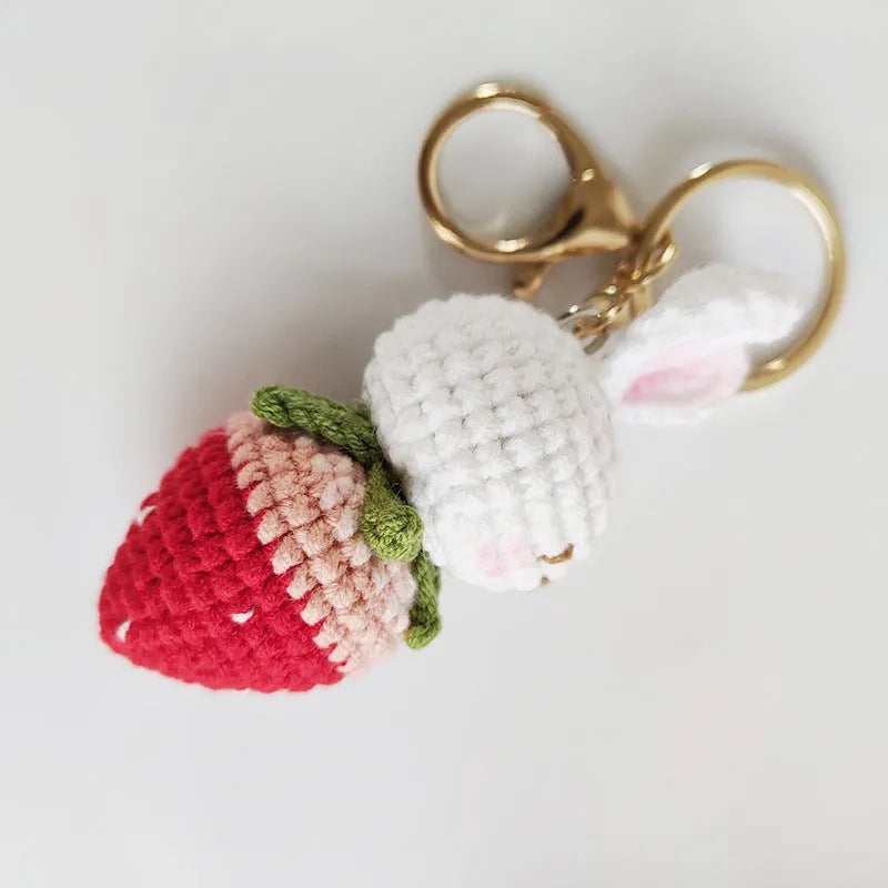 Hand-woven white rabbit strawberry cartoon charm pendant with a key attached