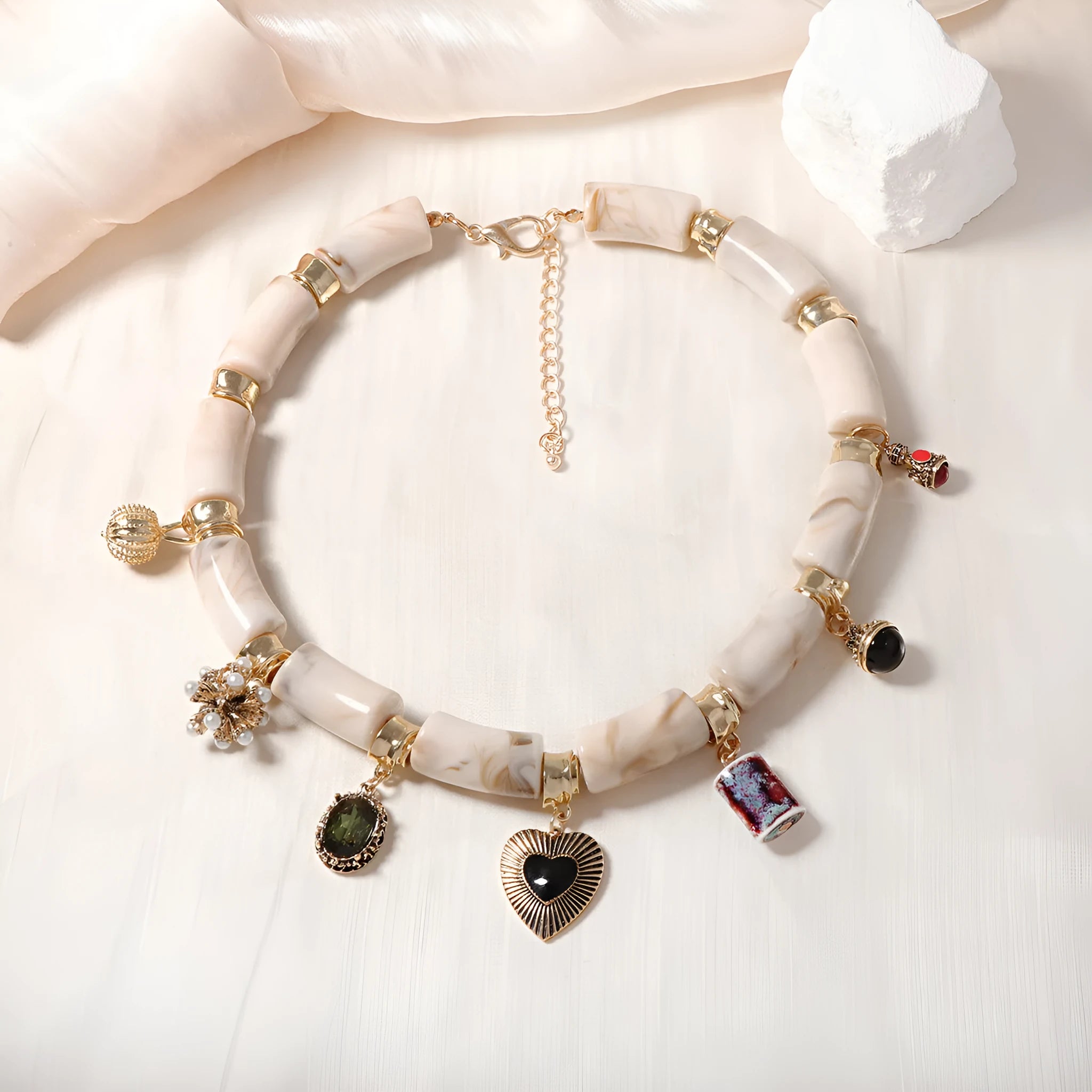 Bamboo-shaped resin pendant necklace with heart charm and electroplated finish.