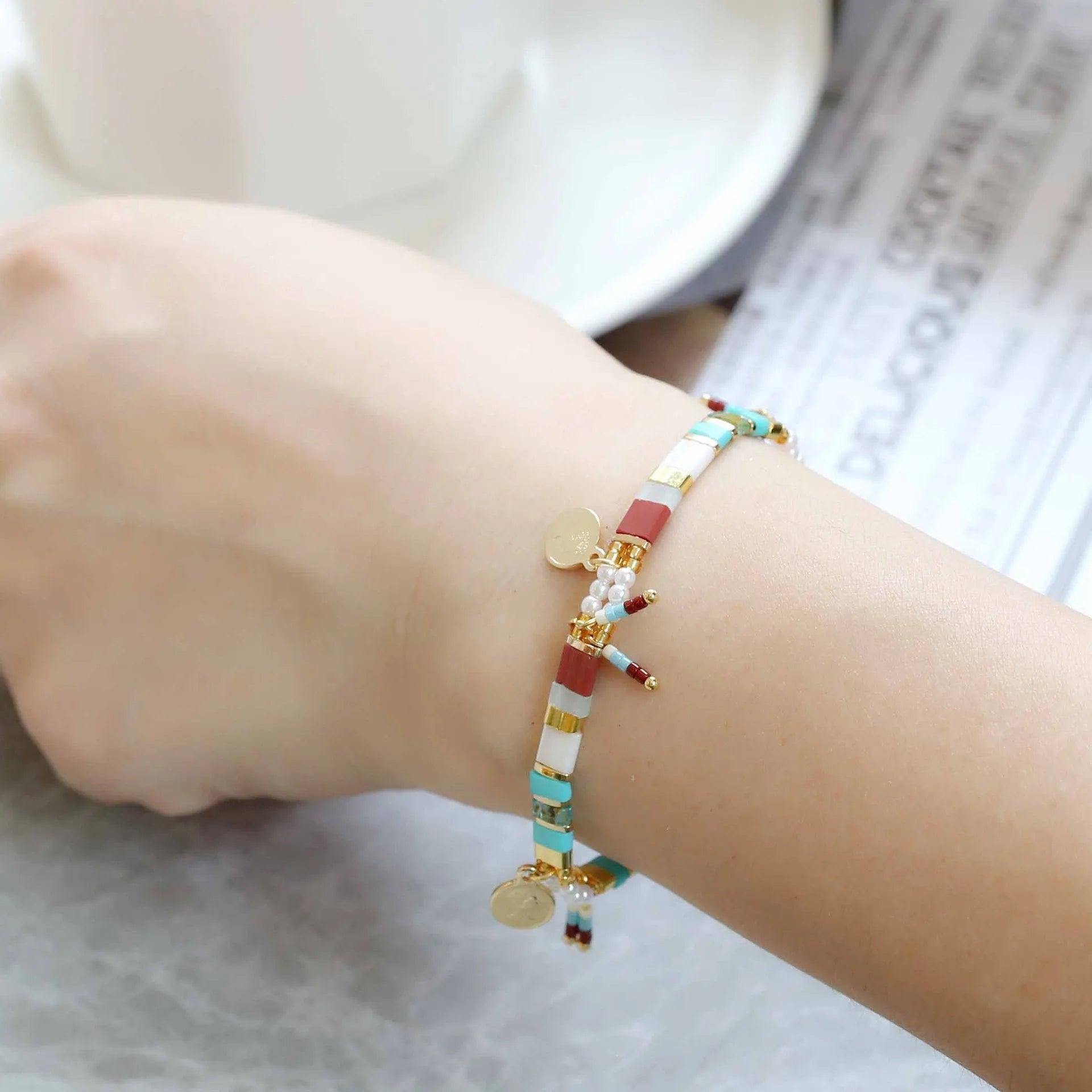Women's handmade bracelet with glass coloured imitation pearl beads on wrist, showing one of six available colour styles.