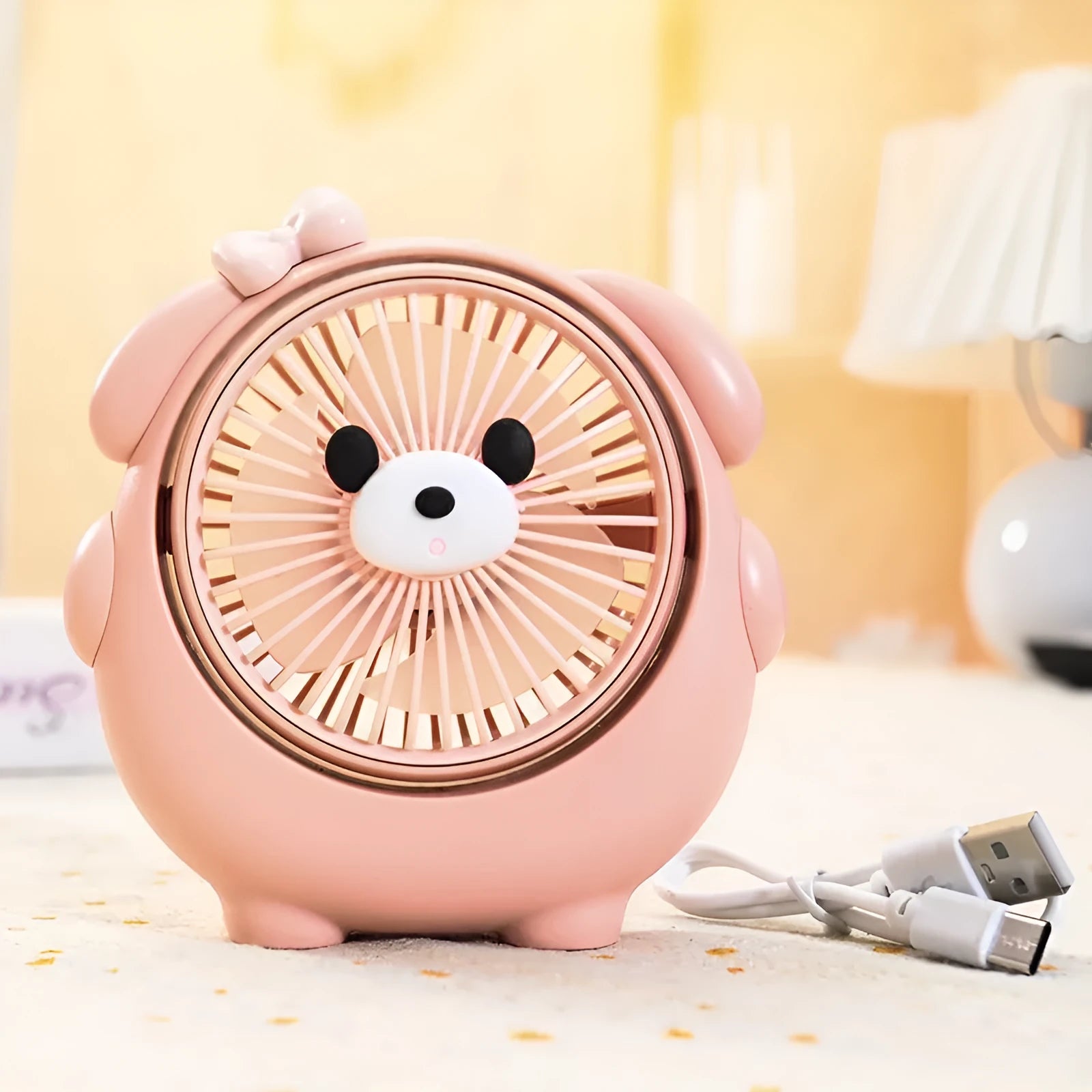 Cute dog-shaped desktop USB fan in a choice of colours on a wooden desk.