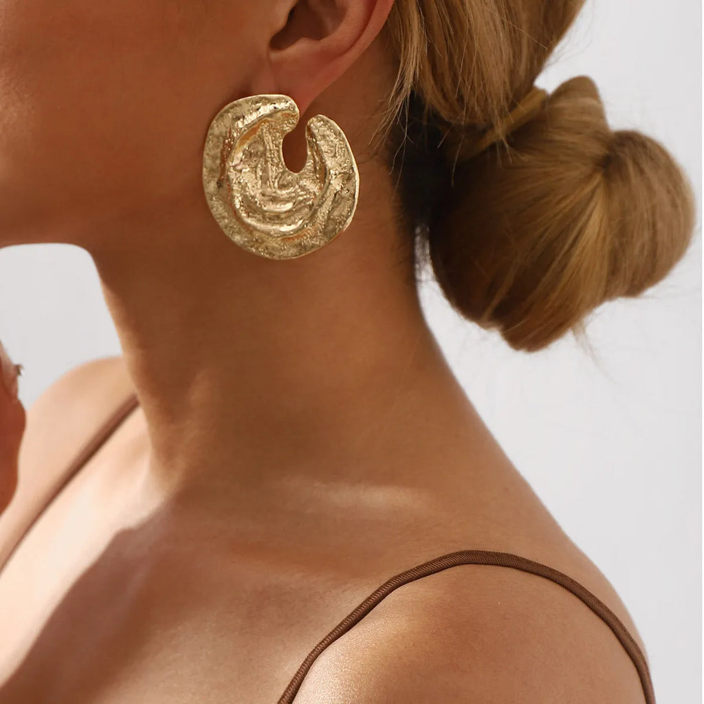 Geometric women's earrings with gold pleating and a concave-convex textured surface.