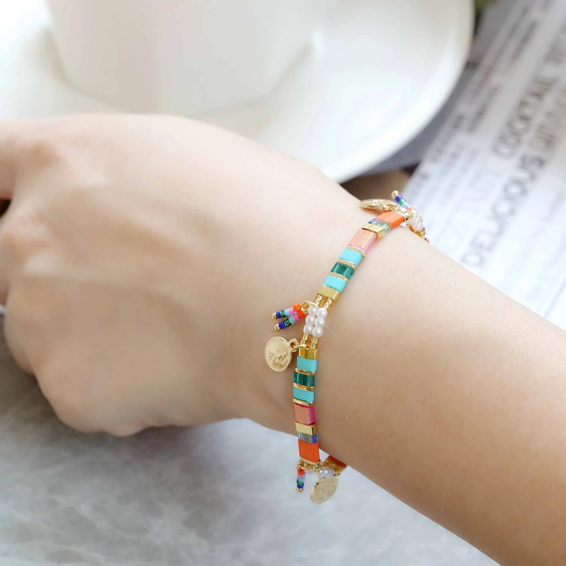 Women's handmade bracelet with glass coloured imitation pearl beads on wrist, showing one of six available colour styles.
