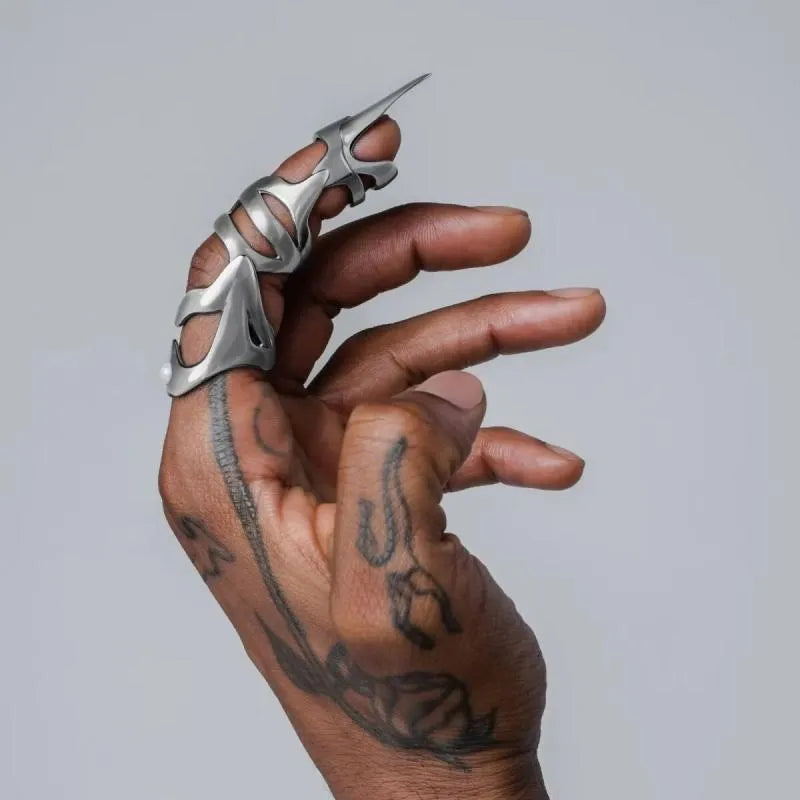 Silver alloy punk armour finger covers laid out on a dark surface.