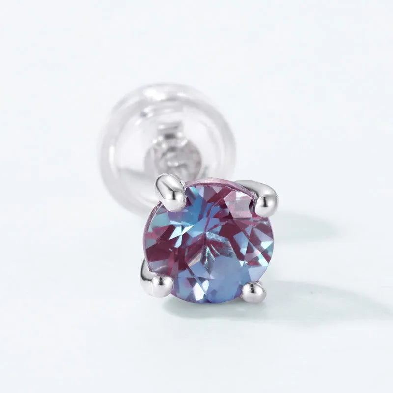 A pair of simple geometric silver ear studs with a round cultivated Alexandrite stone.
