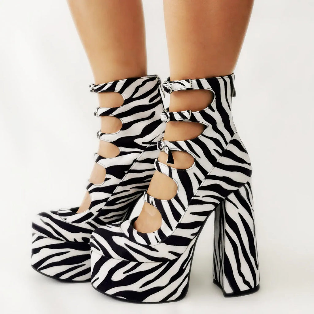 Women's black patent leather platform ankle boots with a thick block heel and a serpentine ankle strap with buckle.