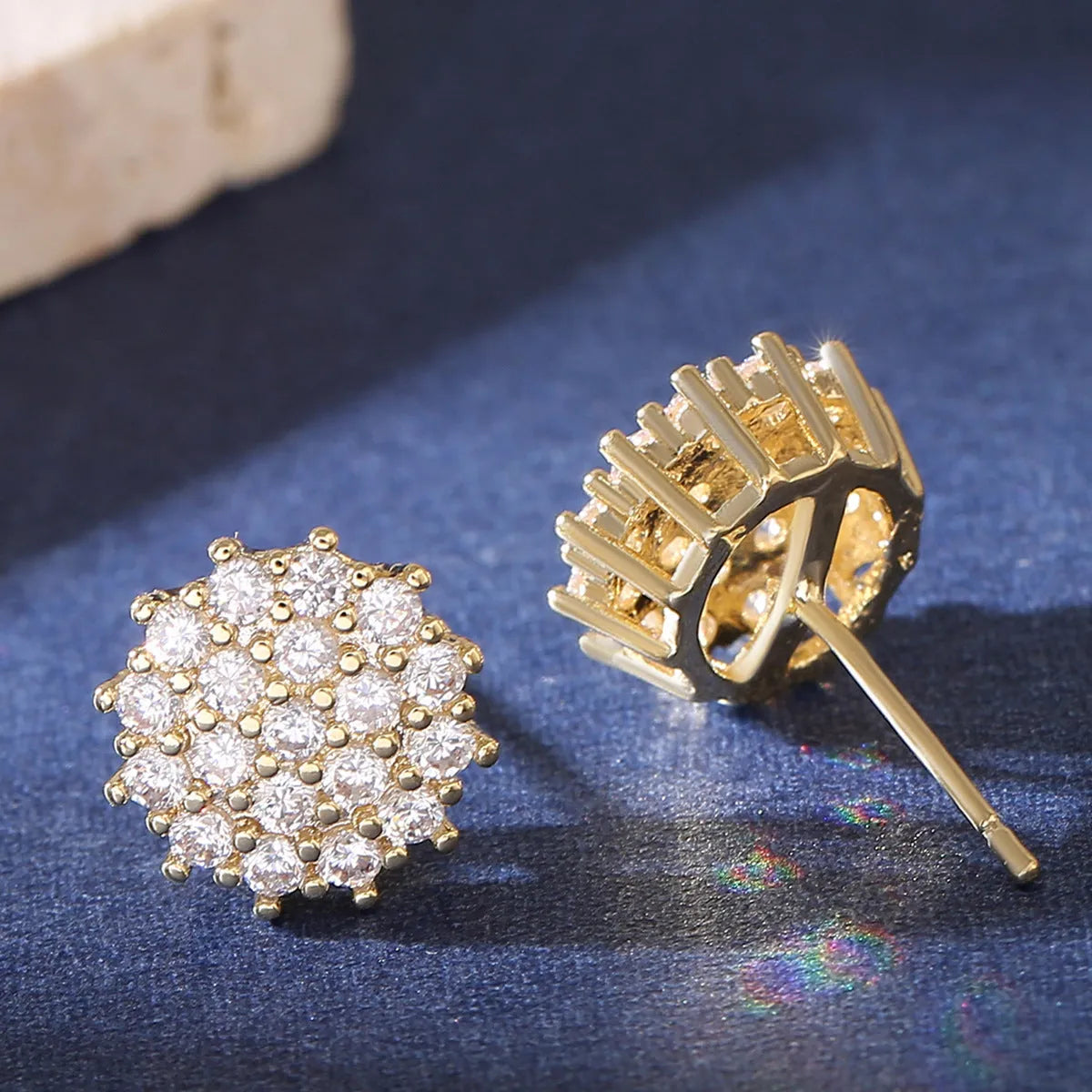 Pair of copper electroplated stud earrings in silver with irregular and round shapes on white background