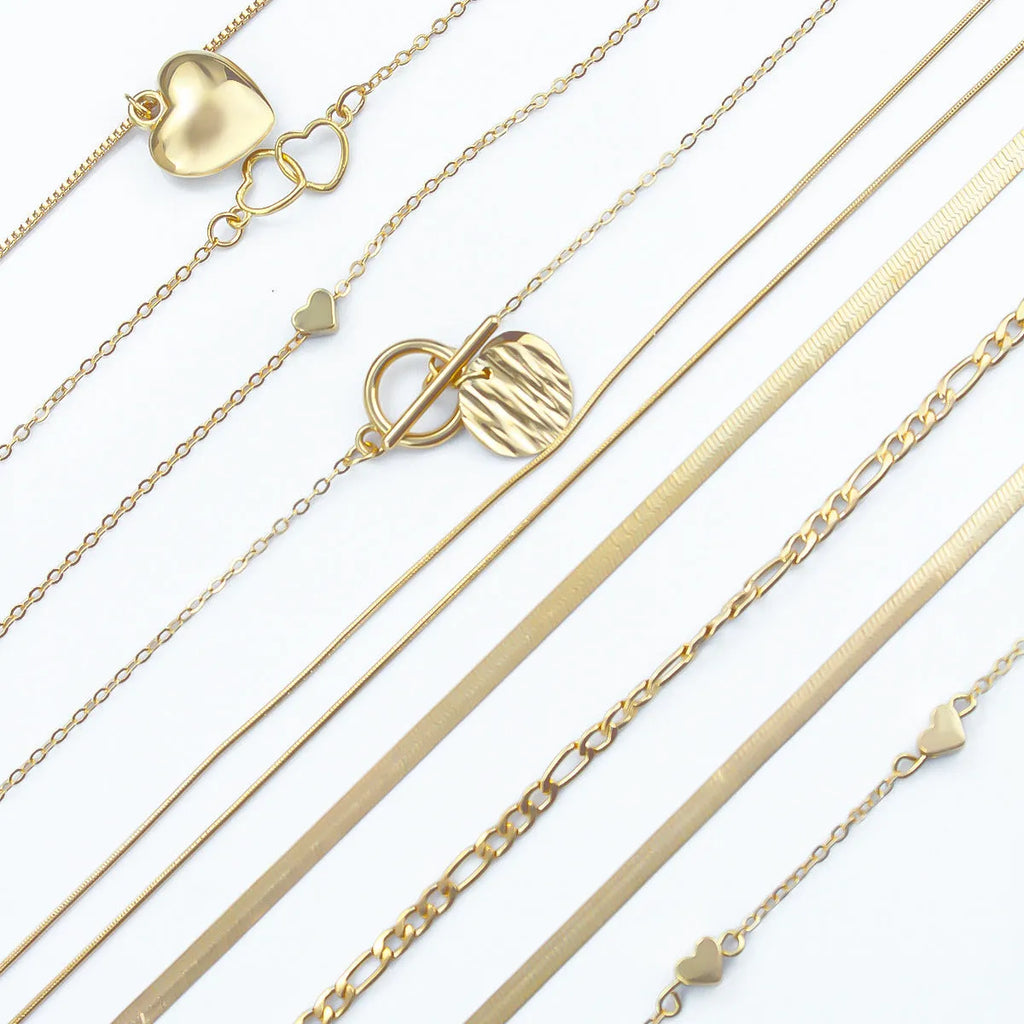Ten gold necklaces with snake bone chains and alloy pendants displayed as complete jewellery set