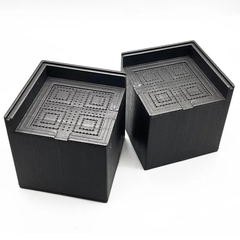 Black plastic furniture height adjustment mats in four-piece set for bed and sofa feet