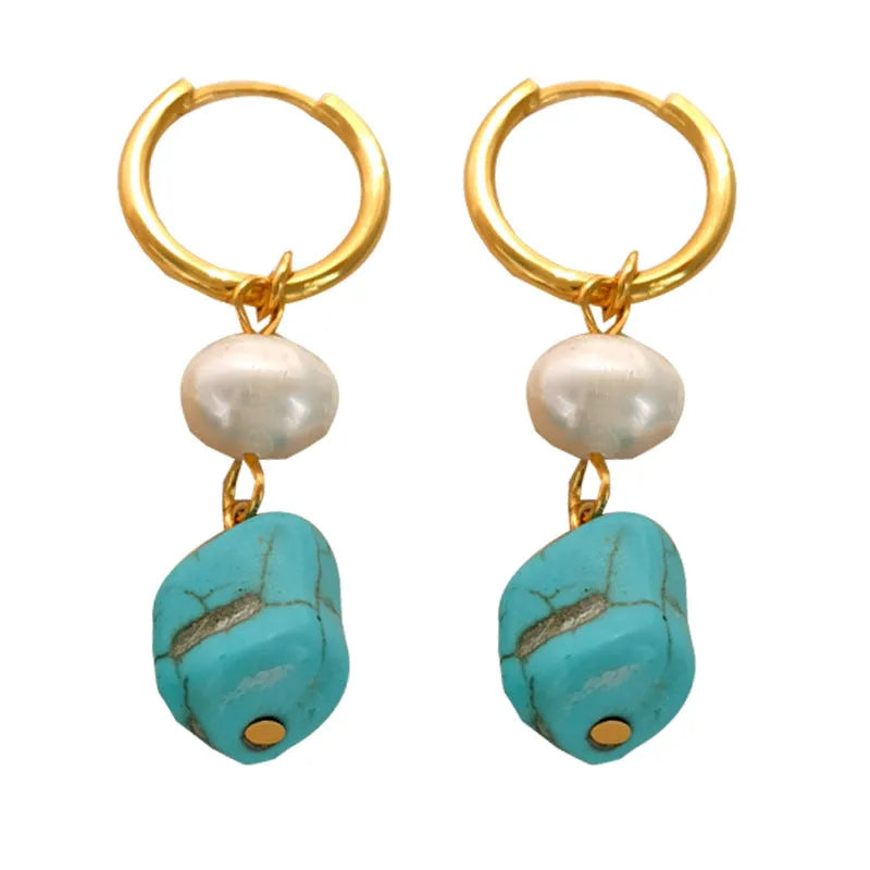 A pair of long dangle earrings with an irregular turquoise geometric clip and a cultured pearl drop on a copper setting.