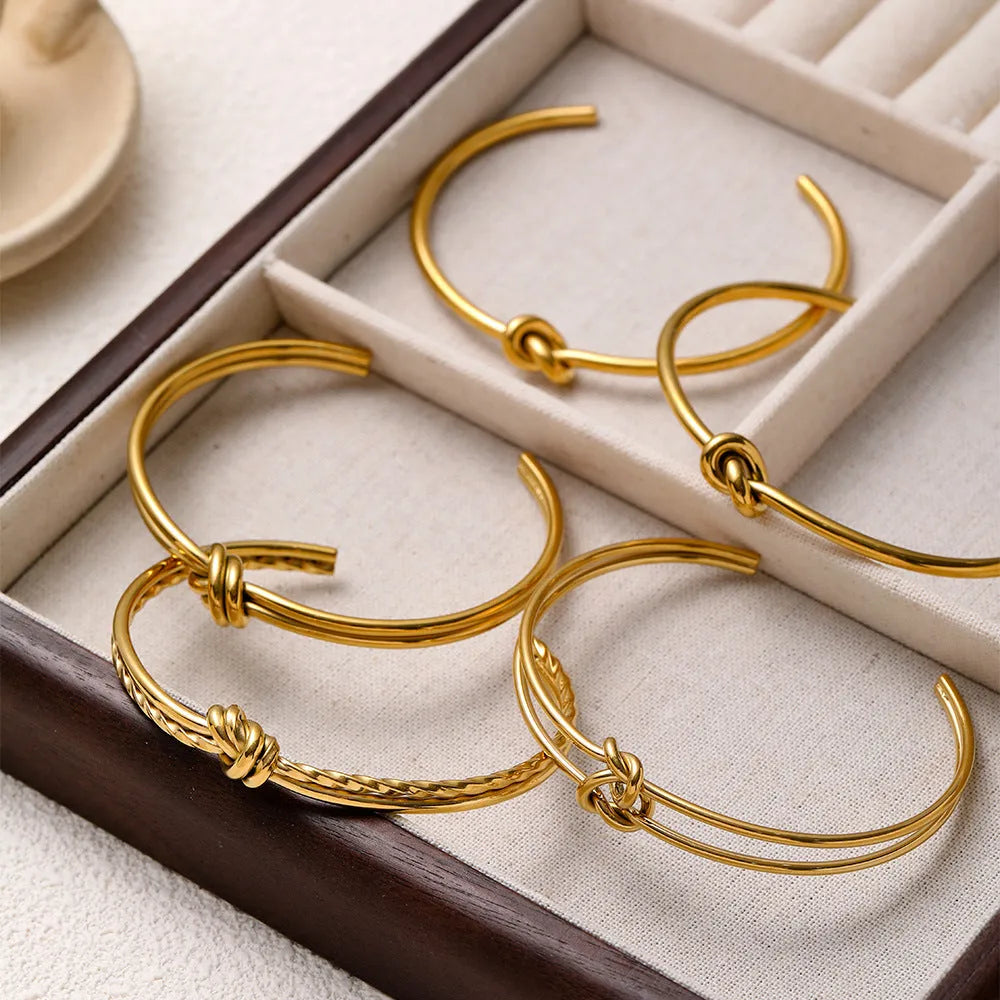 Adjustable stainless steel bracelet with 18K gold plating and knotted C-shaped open design