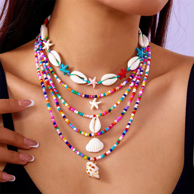 Five-piece women's necklace set with starfish shell and conch bead designs on adjustable chain