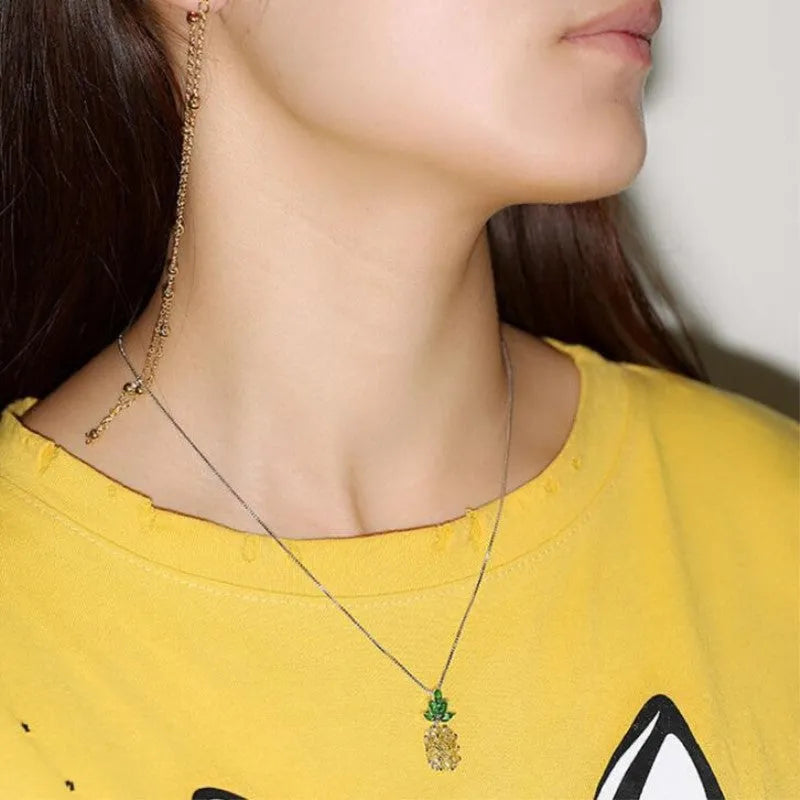 Silver coloured geometric pineapple diamond pendant necklace on a chain.