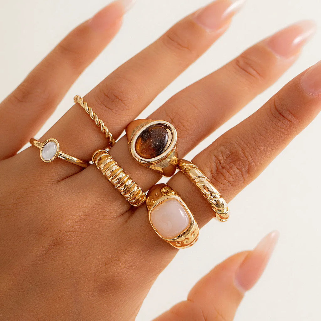 Six irregular geometric alloy rings in light gold electroplated finish arranged as jewellery set