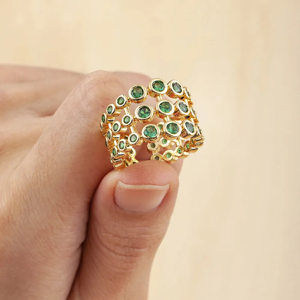 Copper ring with gold plating showing three-layer green stone setting and zircon detailing on wide band.