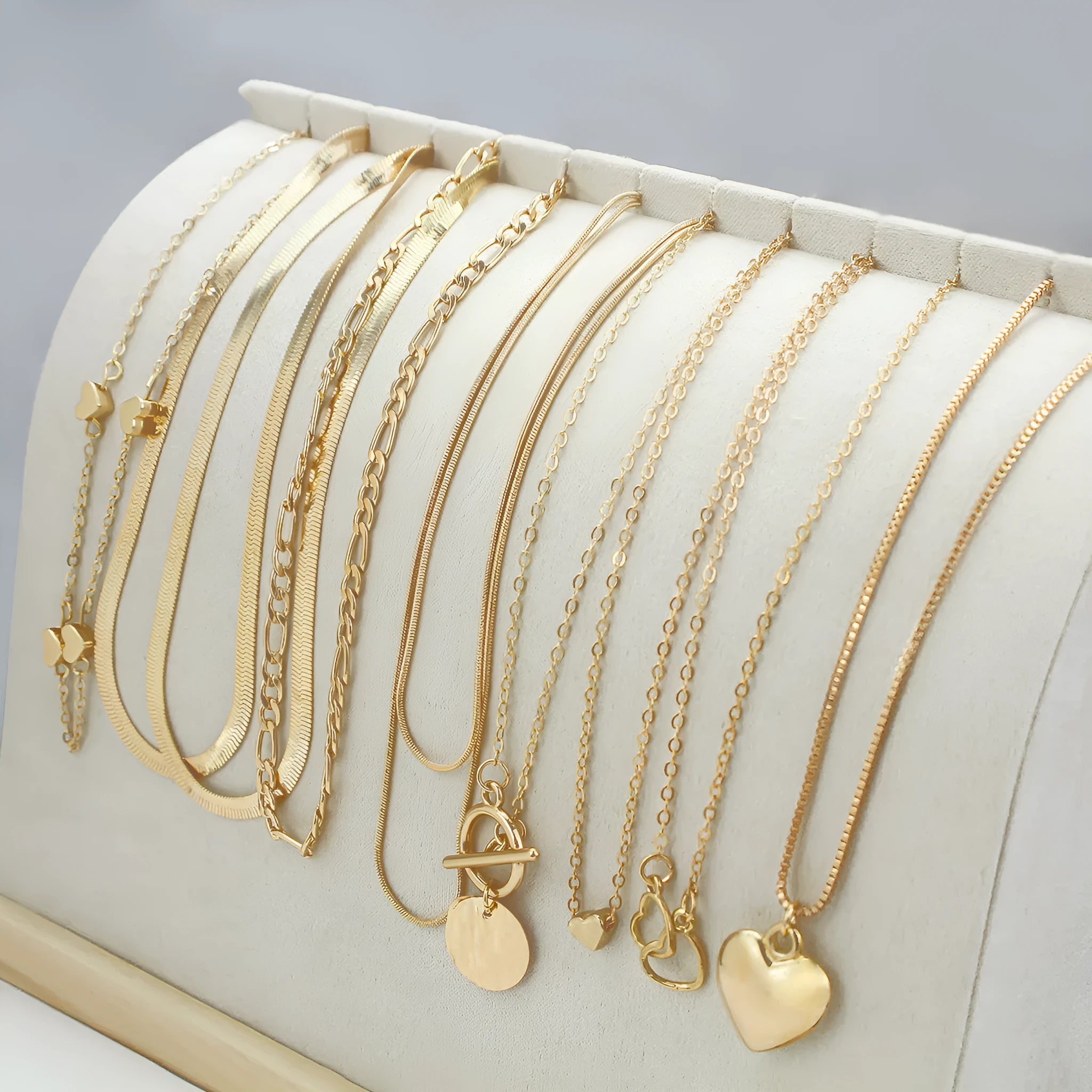 Ten gold necklaces with snake bone chains and alloy pendants displayed as complete jewellery set