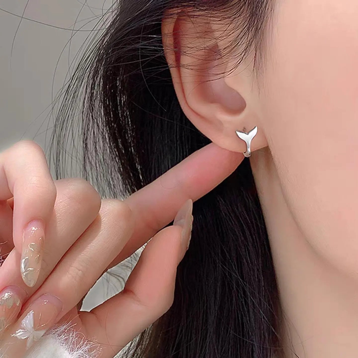 A pair of simple women's fishtail earrings with an electroplated metallic finish.