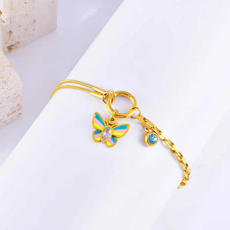 Gold colour titanium steel necklace and bracelet set with a detailed epoxy butterfly charm.