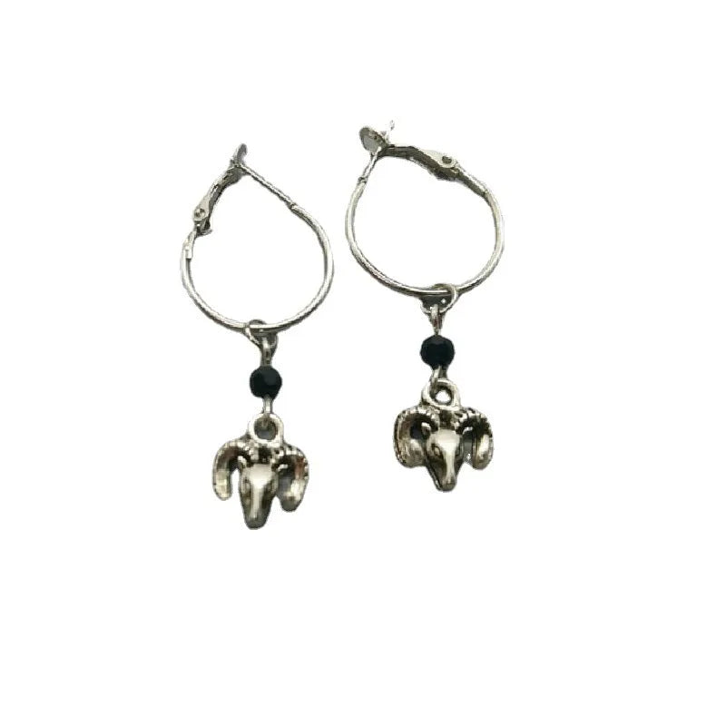 A pair of silver-coloured alloy round earrings featuring a Tibetan antelope design motif.