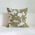 Green cotton and linen hotel sample pillow with botanical pattern and tassel detail on a display bed.