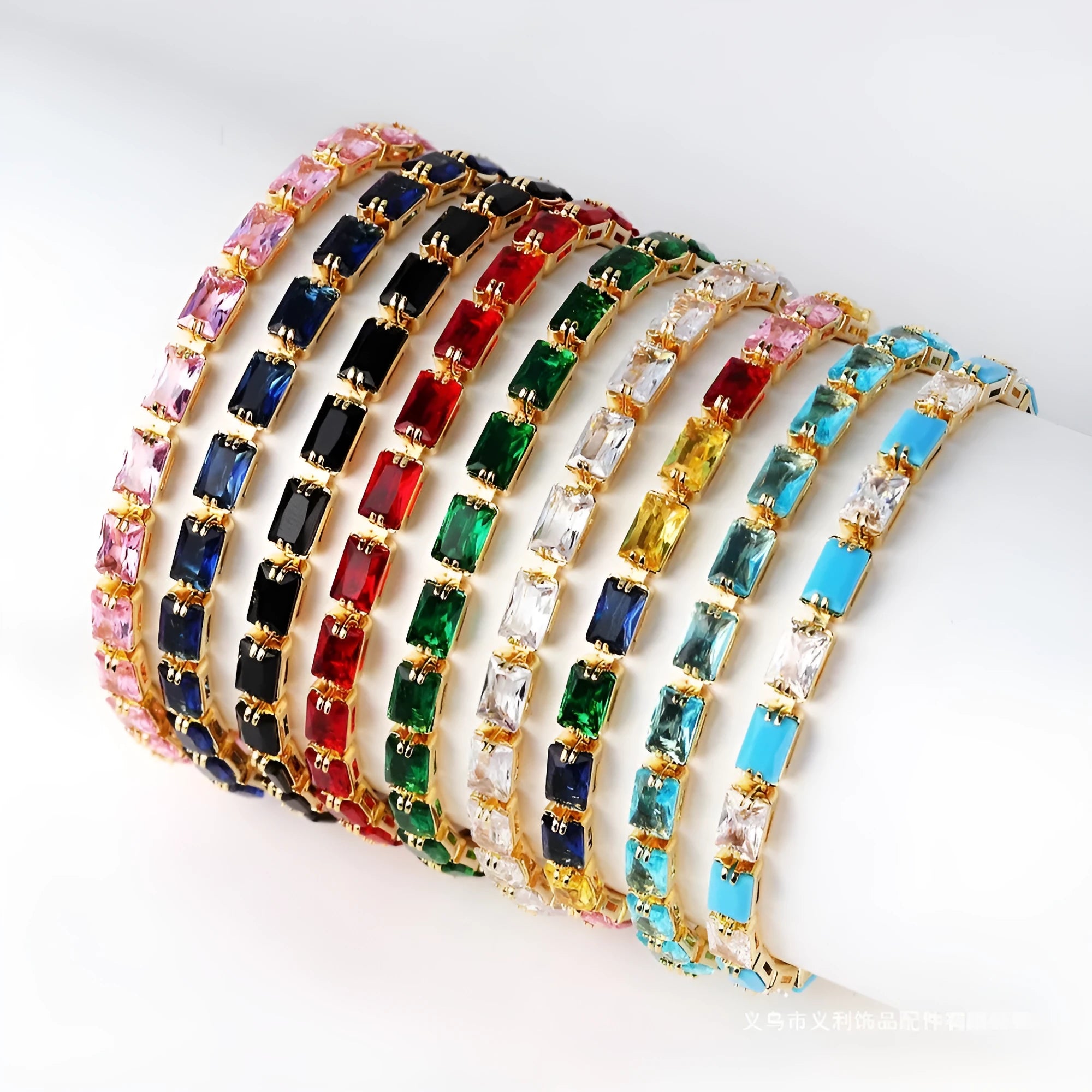 Women's fashion zircon bracelet in alloy with gold electroplated finish and coloured stone settings.