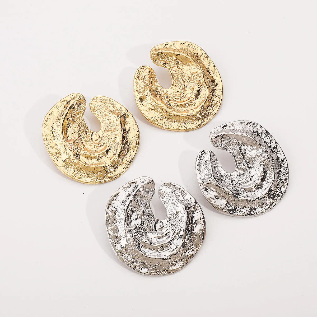 Geometric women's earrings with gold pleating and a concave-convex textured surface.