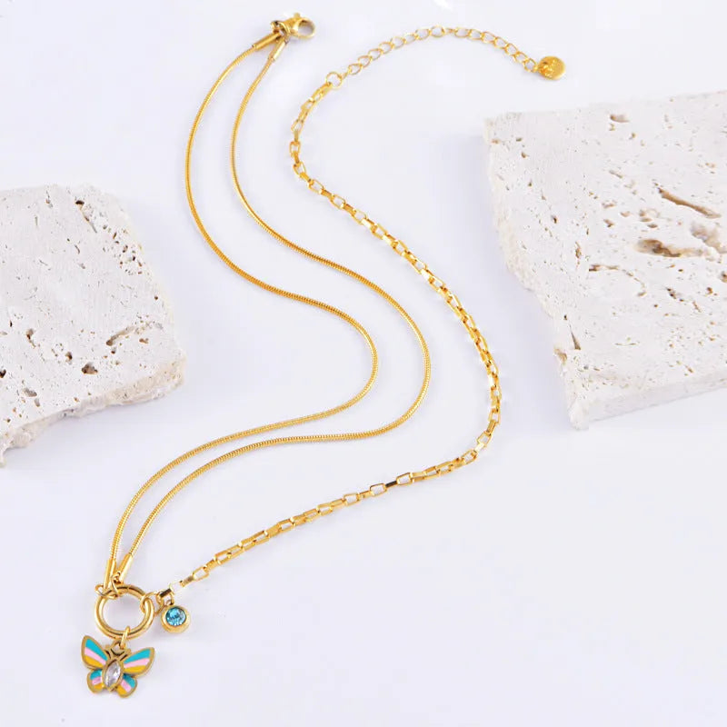 Gold colour titanium steel necklace and bracelet set with a detailed epoxy butterfly charm.