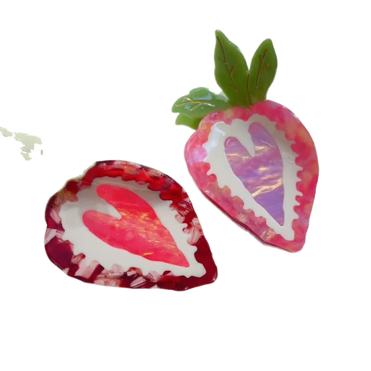 A close-up of a handmade strawberry-shaped hairpin in either red or pink colour on a light background.