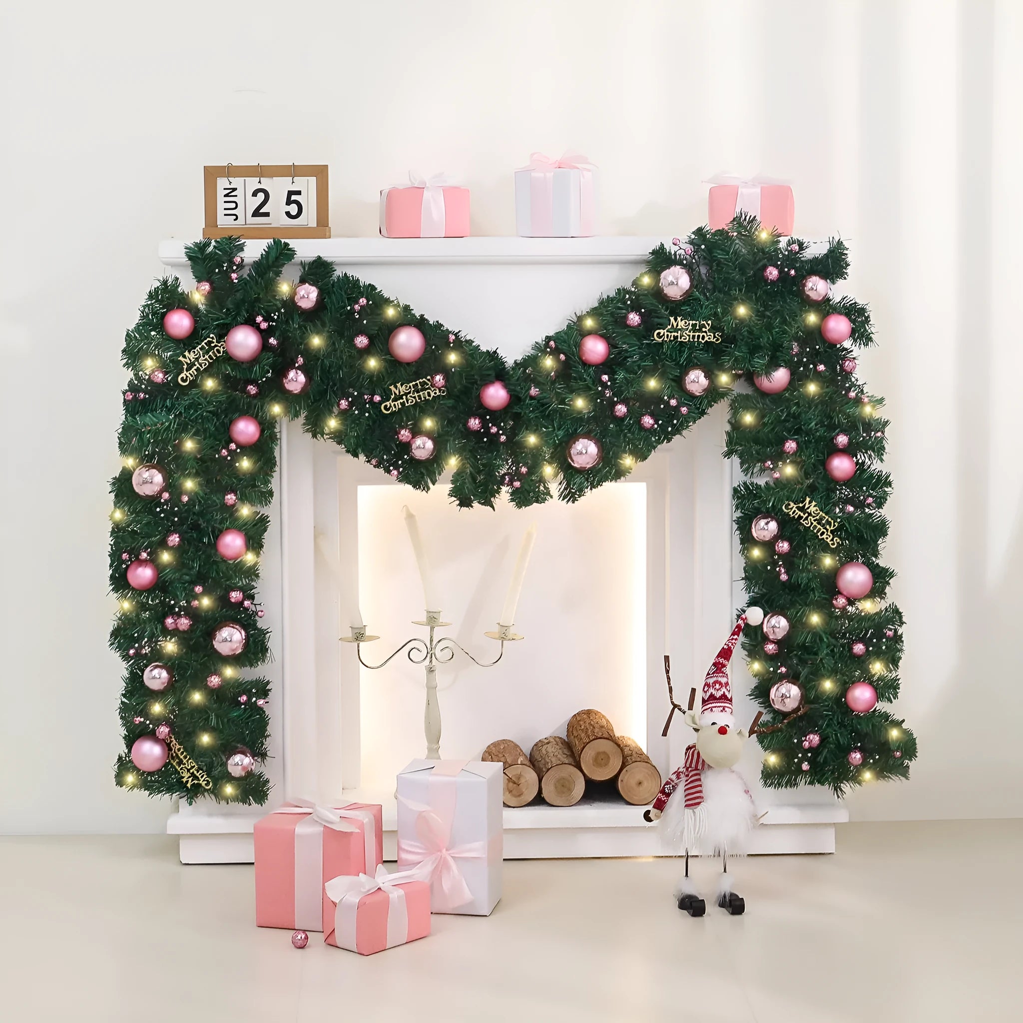 Long pink Christmas rattan garland with small decorative fruits and warm white LED lights draped on a mantelpiece.