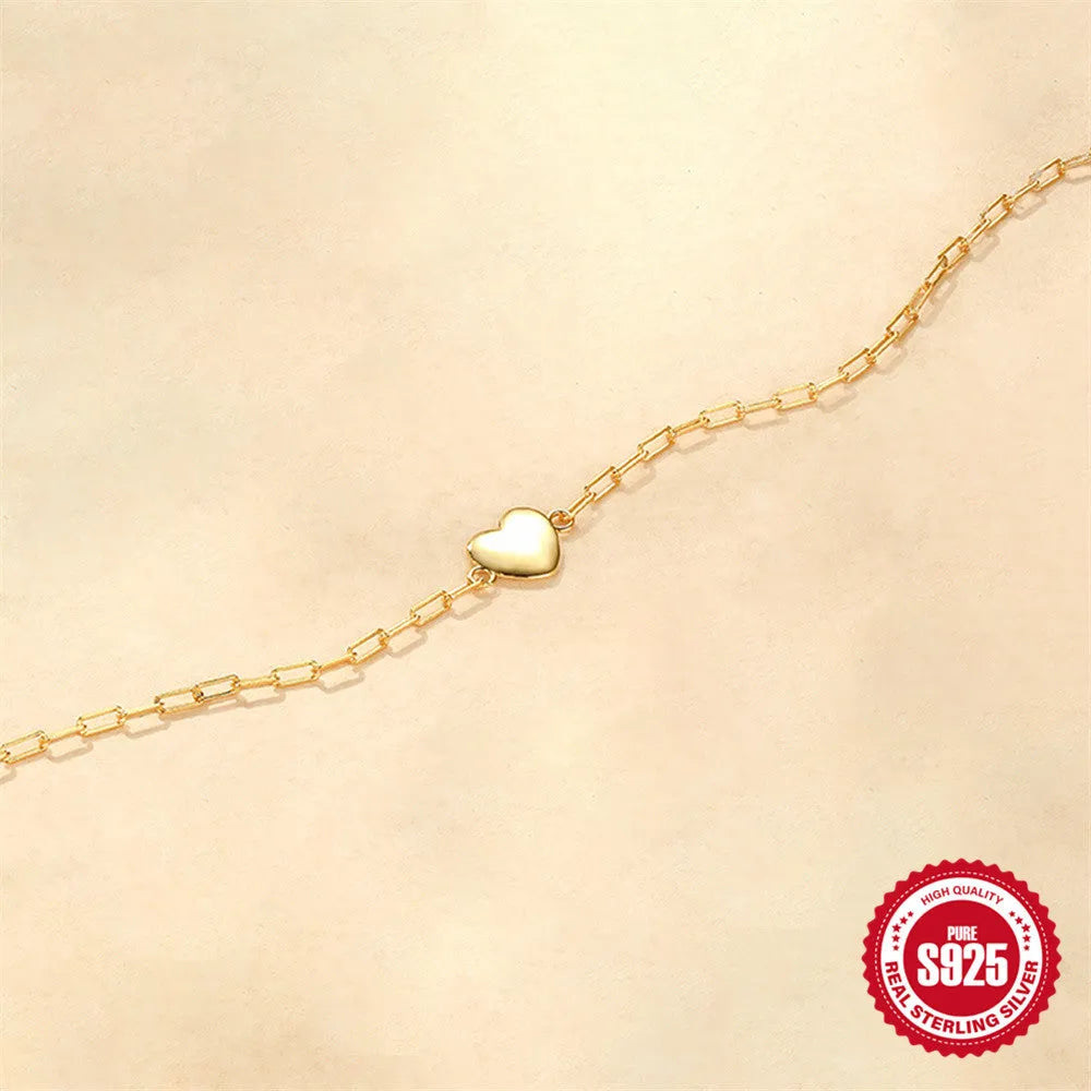 S925 sterling silver bracelet with clip chain fastening and glossy gold heart charm