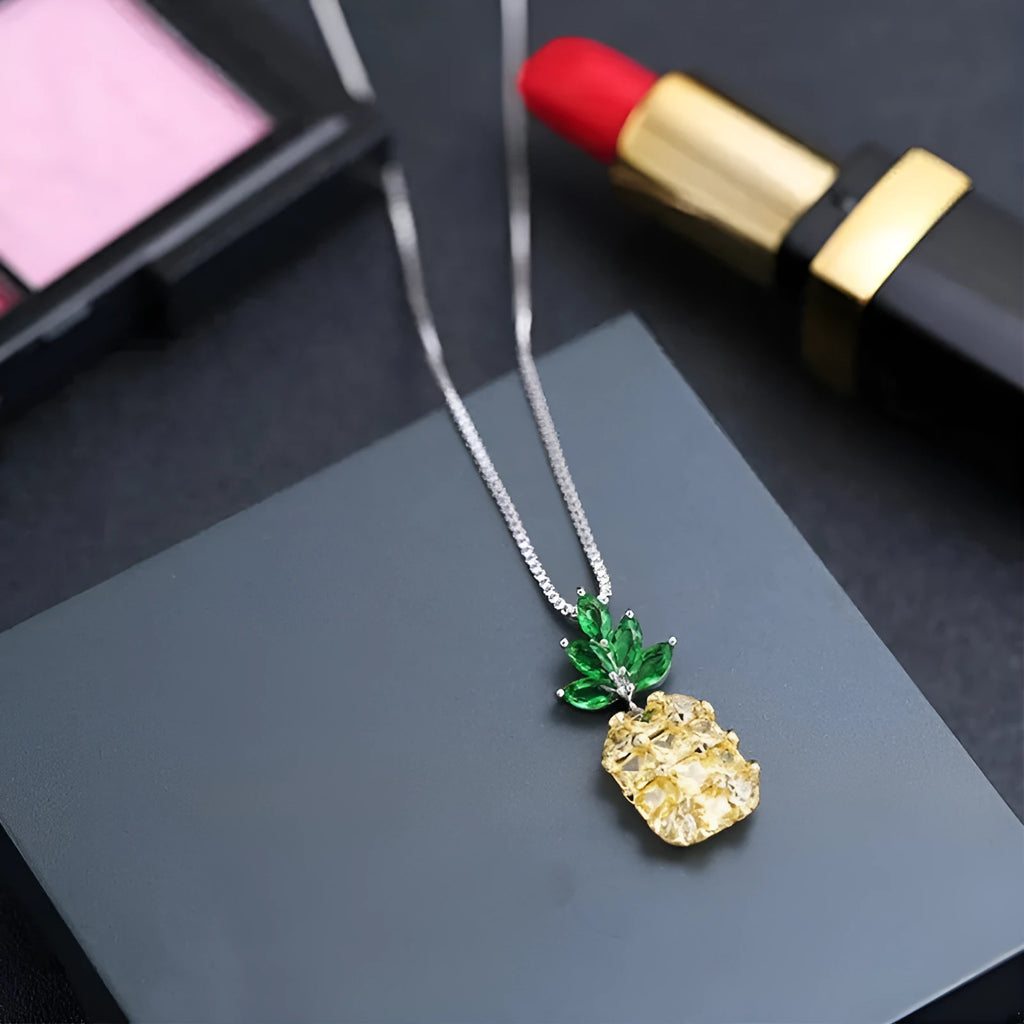 Silver coloured geometric pineapple diamond pendant necklace on a chain.