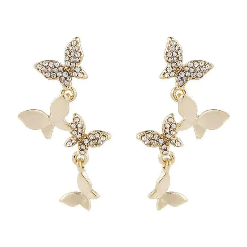 Gold tone butterfly drop earrings with four copper charms on each piece for women