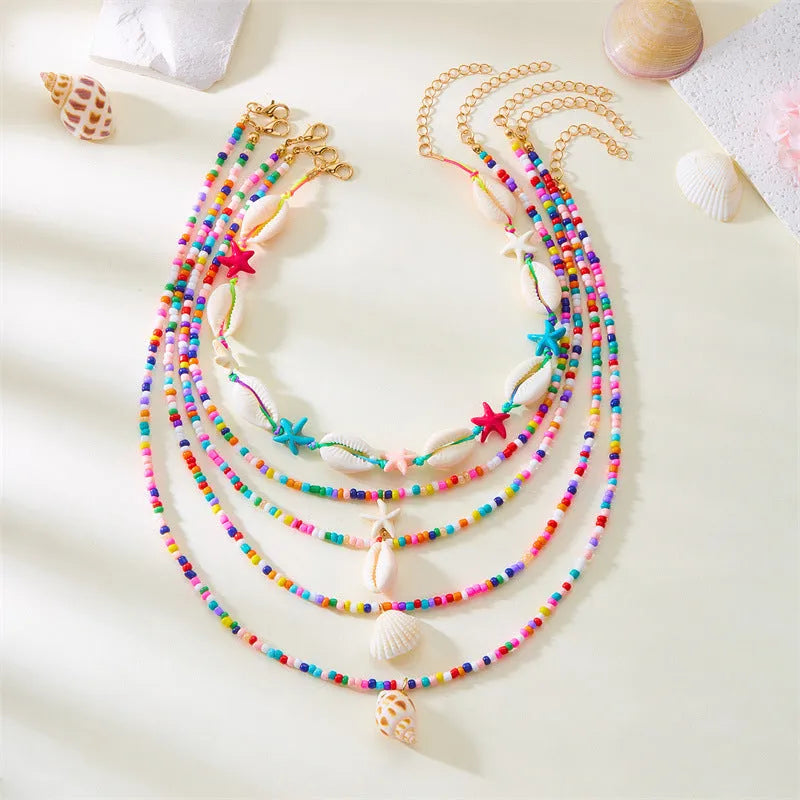 Five-piece women's necklace set with starfish shell and conch bead designs on adjustable chain