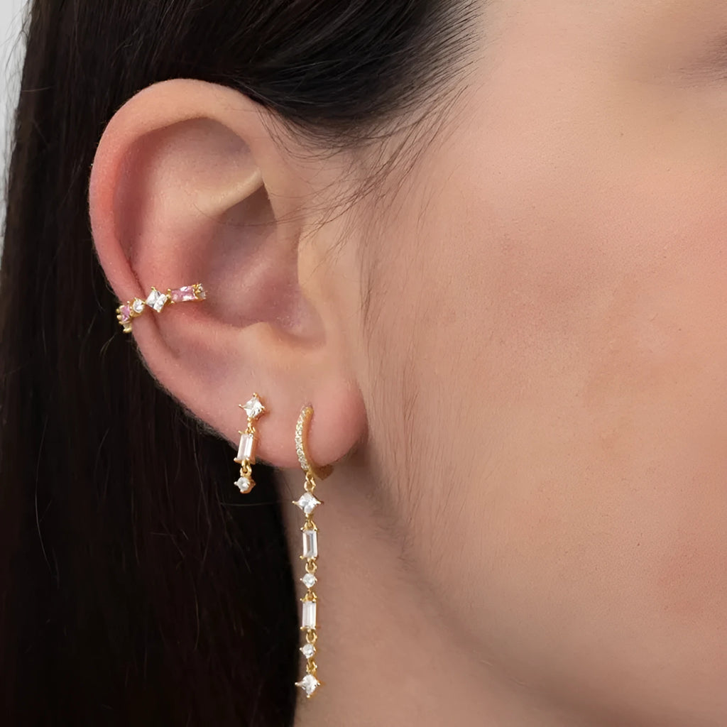 Geometric U-shaped ear clip with colourful stone inlays and metallic framework on earlobe