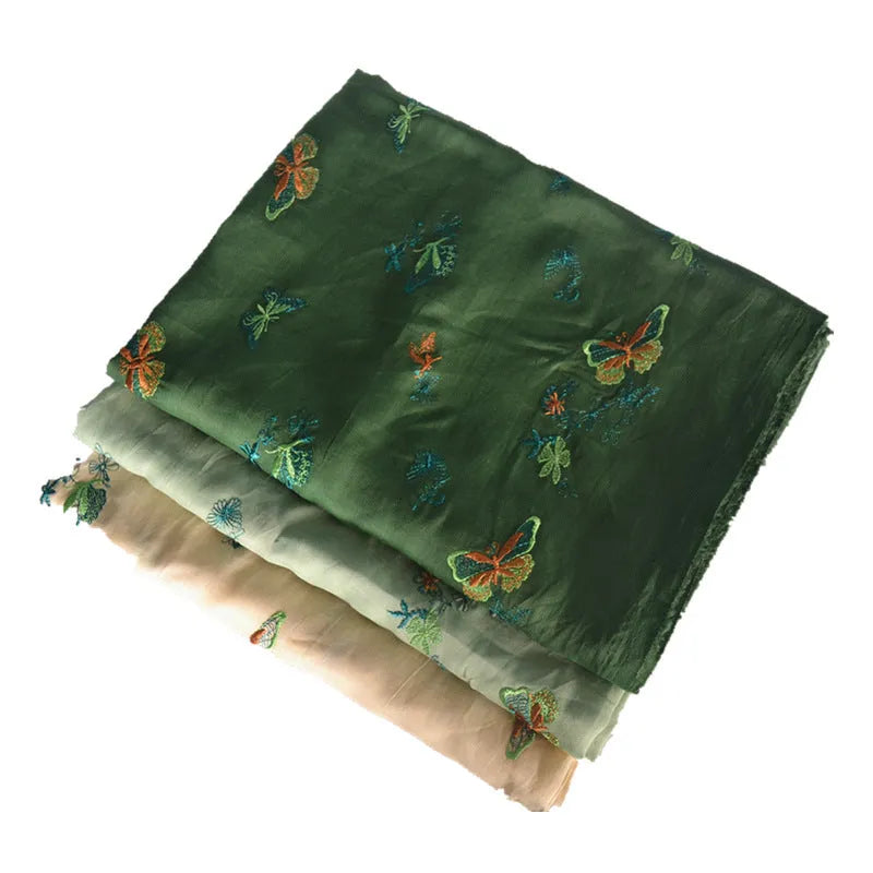 Close-up of textured 100% ramie fabric in beige, grass green, and dark green colours, showing its width.