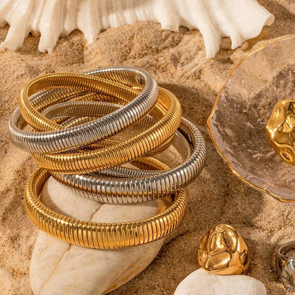 Women's titanium steel elastic bracelet with vertical stripe pattern in gold or silver, shown in various width sizes