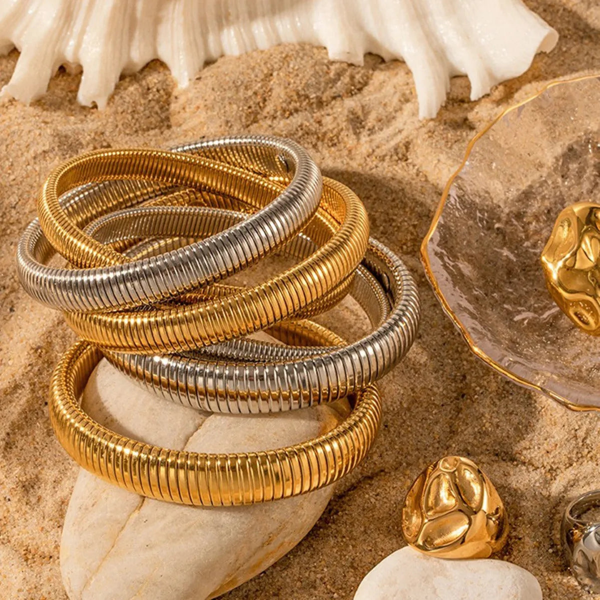 Women's titanium steel elastic bracelet with vertical stripe pattern in gold or silver, shown in various width sizes