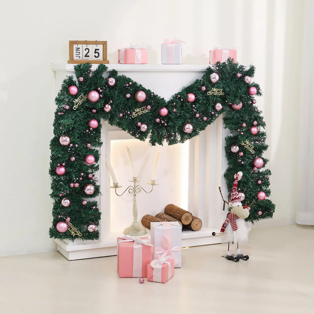 Long pink Christmas rattan garland with small decorative fruits and warm white LED lights draped on a mantelpiece.