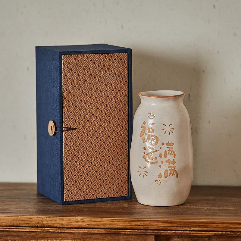 Chinese hand-painted ceramic vase with carved design on wooden desk