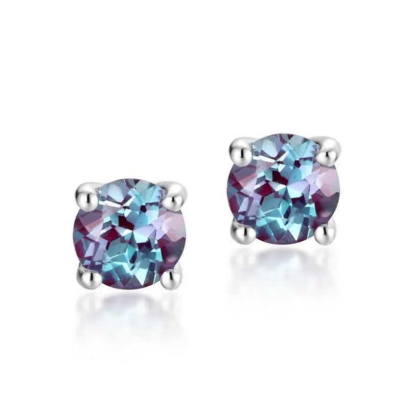 A pair of simple geometric silver ear studs with a round cultivated Alexandrite stone.