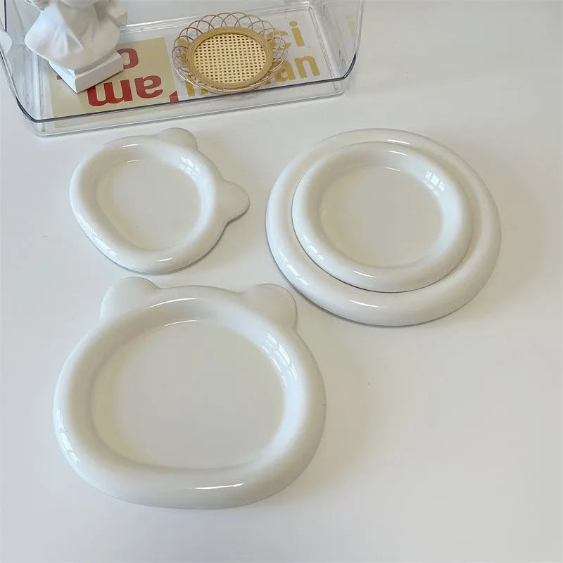 White porcelain plate with doodle design, shown in round and bear shapes, small and large sizes.
