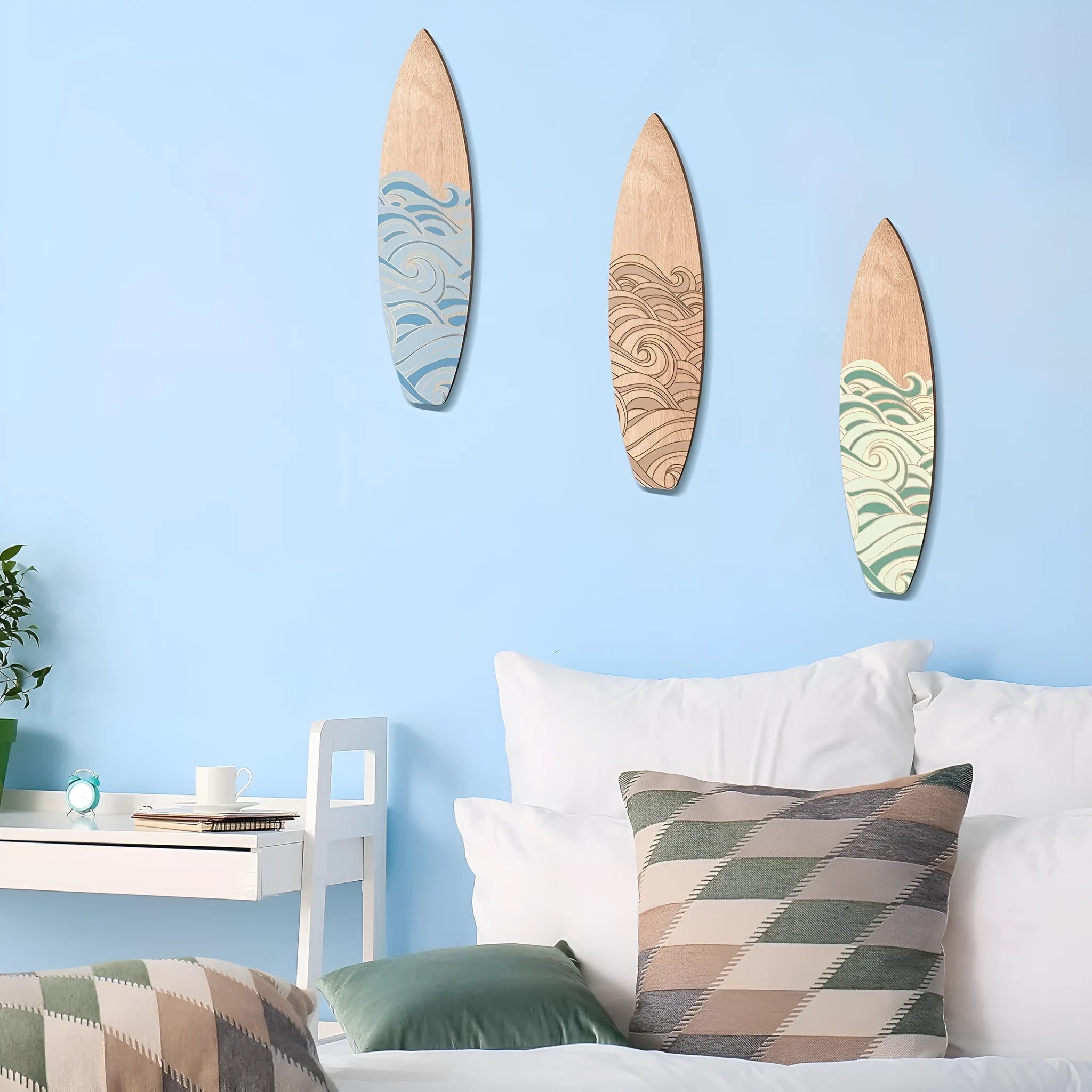 Three natural wooden surfboard wall decorations on a light wall
