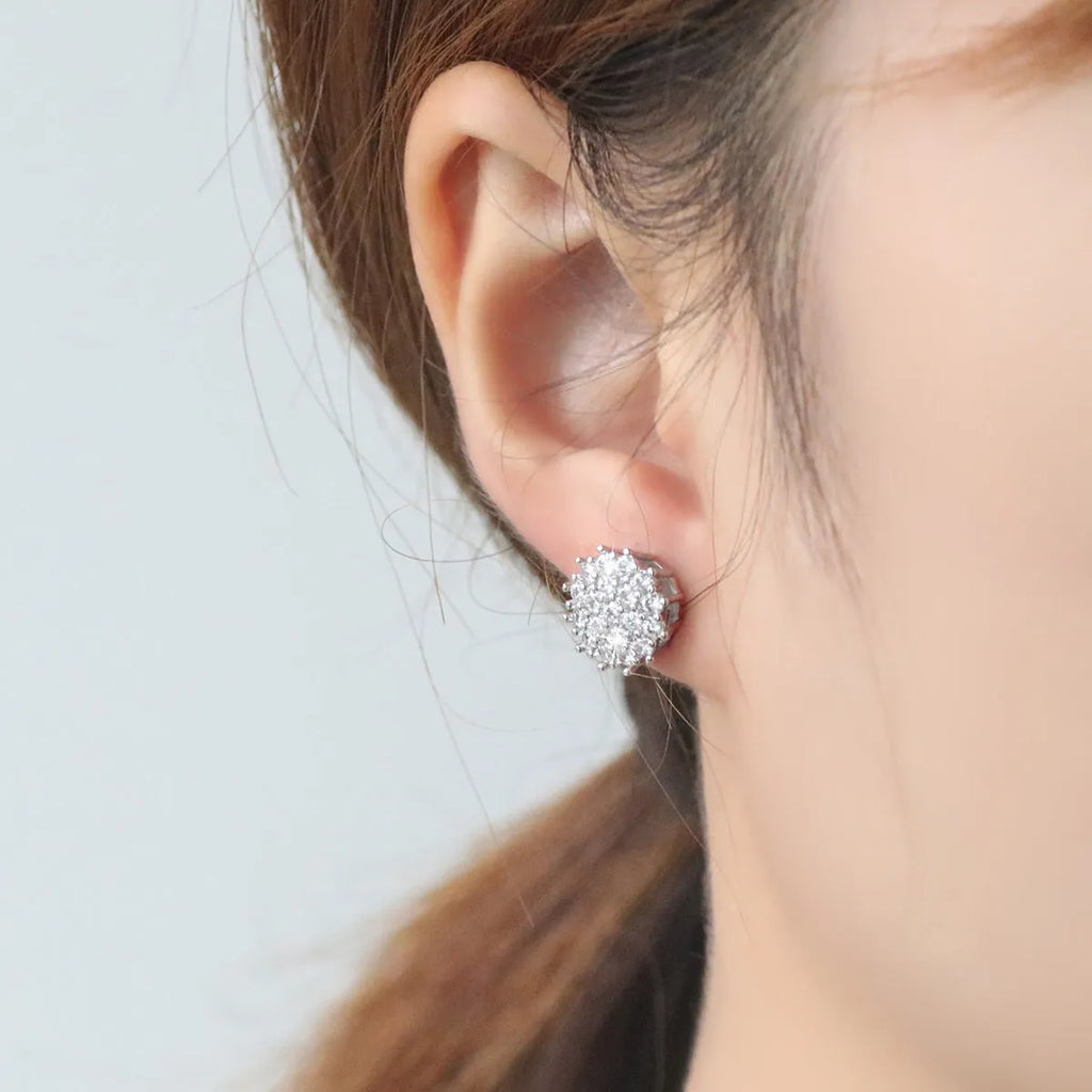 Pair of copper electroplated stud earrings in silver with irregular and round shapes on white background