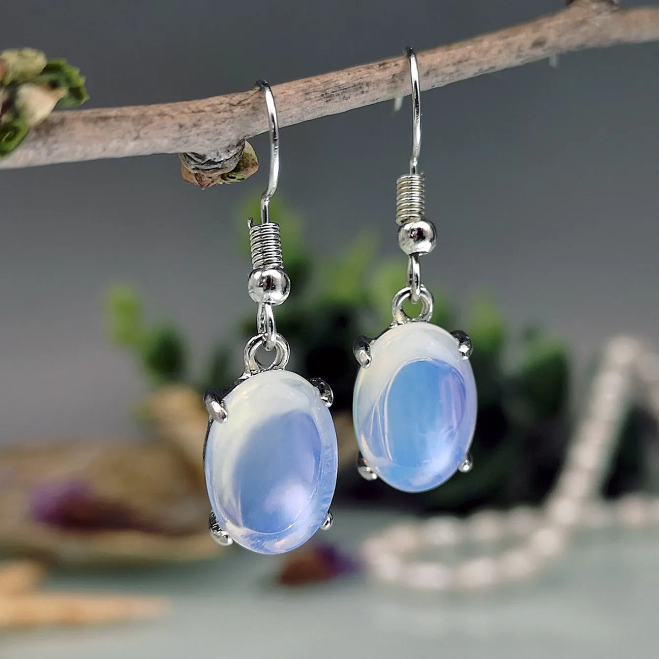 A pair of opal drop earrings with a retro moonstone design and electroplated alloy finish in a moonlight white colour.