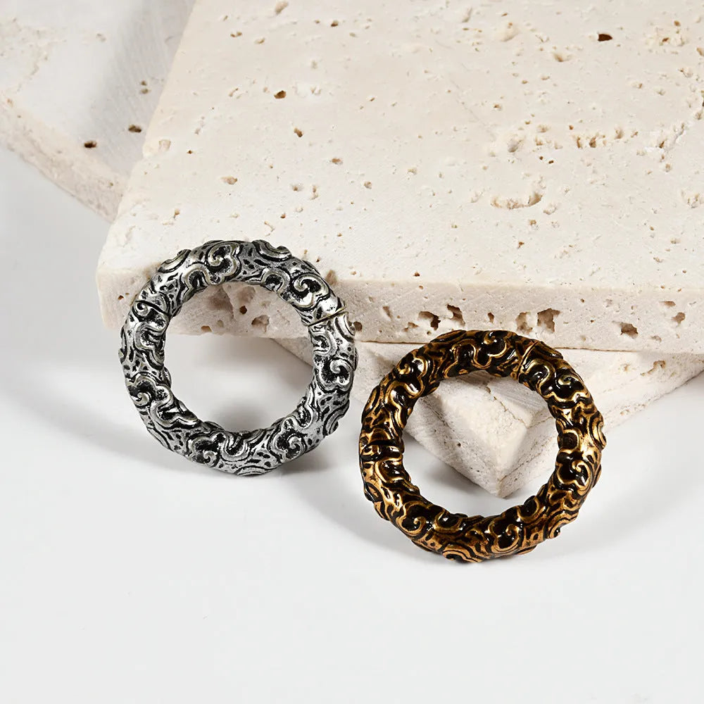 Stainless steel fashion earrings with a detailed totem pattern in an electroplated metallic finish