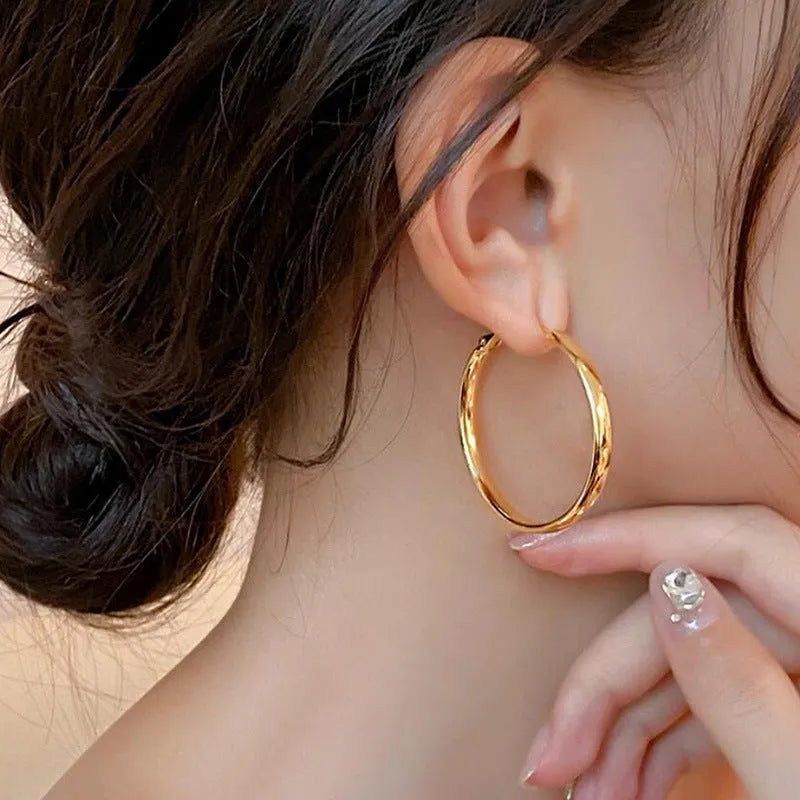 A pair of gold-coloured metal circle hoop earrings on a 40mm diameter.