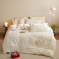 Milk fibre winter bedding four-piece set with green Christmas tree pattern on a bed.